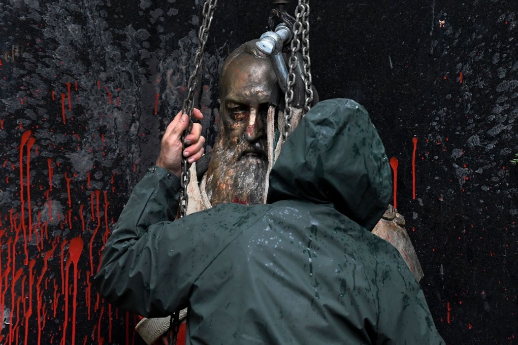 A person helps to remove the vandalised statue of King Leopold II of Belgium, notorious for his absolute rule of Congo in the 19th century, in Ghent, Belgium, as the country prepares to celebrate the 60th anniversary of Congolese independence. Photo: AFP