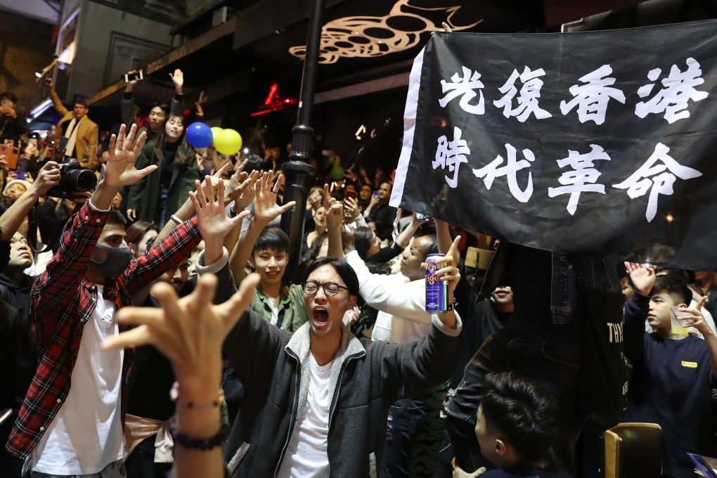 A banner bearing the slogan “Liberate Hong Kong; revolution of our time” is held aloft at a 2020 New Year’s party in Hong Kong’s Central district. Photo: Sam Tsang