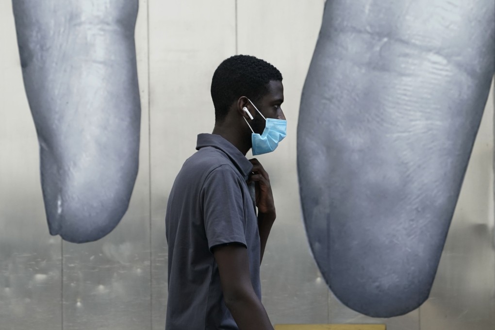 A man walks past a mural in midtown New York on June 26. The next few years could herald a great economic reset, towards more sustainable and equitable directions. Photo: AFP