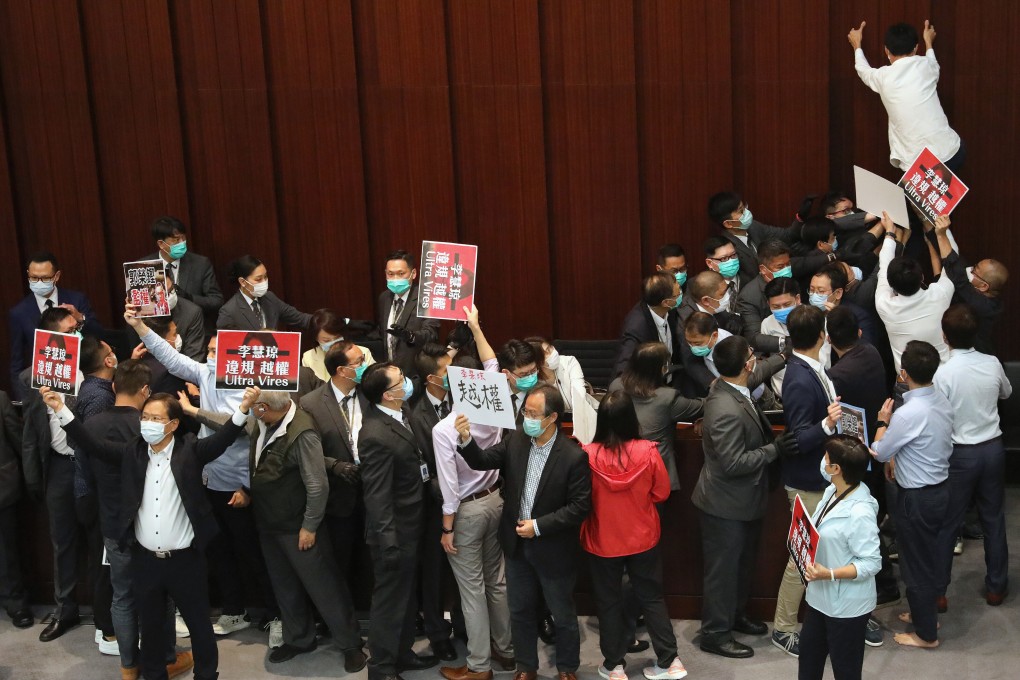 Pro-democracy lawmaker Eddie Chu (right) climbs a wall during the Legislative Council House Committee meeting on May 8 as pan-democrat lawmakers scuffle with their pro-establishment counterparts over lawmaker Starry Lee Wai-king presiding over the committee meeting. Photo: Dickson Lee
