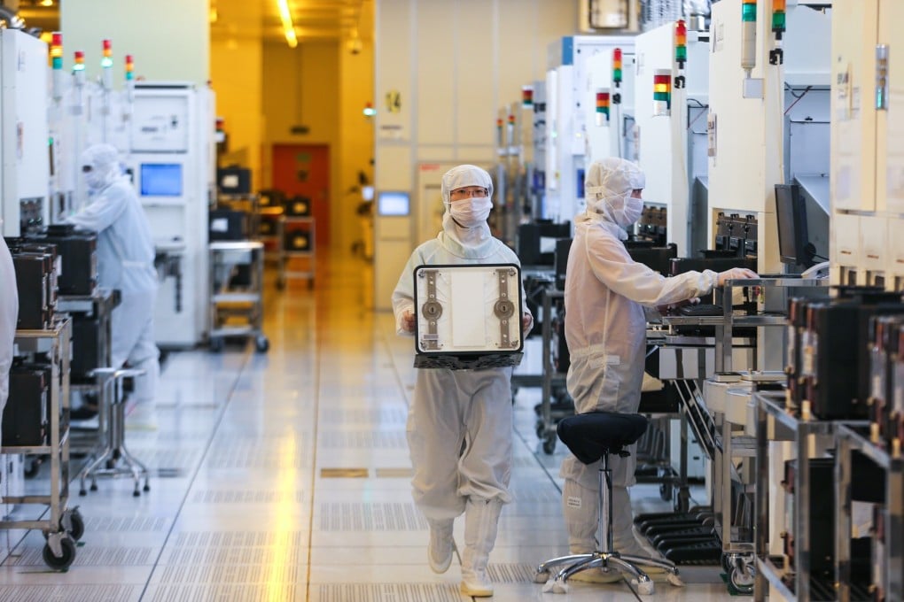 Chinese employees dressed in dust-proof clothing work at SMIC’s plant in Beijing in August 2012. Photo: Imaginechina
