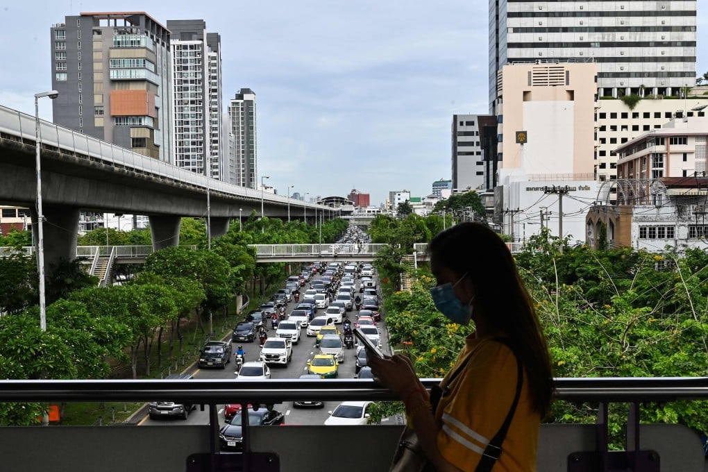 A pedestiran walks through Bangkok during peak hour. Photo: AFP