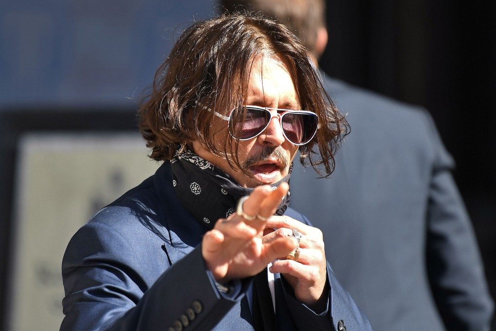 Hollywood actor Johnny Depp removes his face mask to talk to people as he arrives at the High Court in London for the first day of his libel trial against News Group Newspapers. Photo: AFP