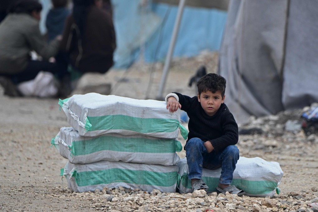A Syrian boy sits next to humanitarian aid, consisting of heating material and drinking water, at a camp along the border with Turkey. File photo: AP
