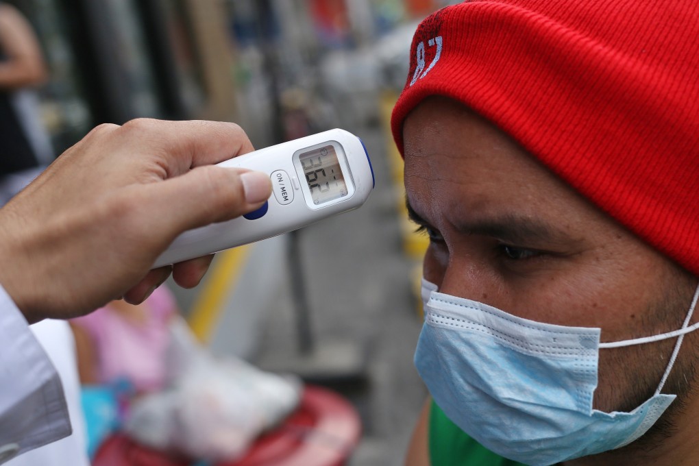 A Philippine man has his temperature taken in Manila. Photo: dpa