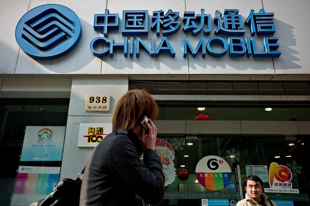 A pedestrian walking past a China Mobile outlet in Shanghai. The telco outbids rivals with record price for an industrial site in Sha Tin amid strong demand for data centre facilities in Hong Kong. Photo: AFP