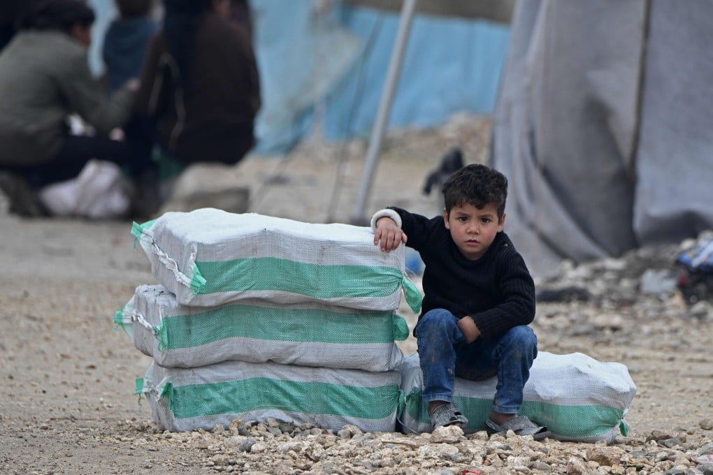 A Syrian boy sits next to humanitarian aid in a camp on February 21. A UN Security Council resolution for a global ceasefire to allow coronavirus aid to the most vulnerable is mired in disagreement. Photo: AFP