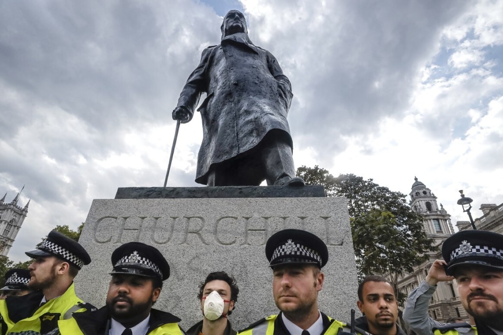 Police officers stand in front of the Winston Churchill statue during a rally in Parliament Square in London, Tuesday, June 9, 2020. The rally is to commemorate George Floyd whose private funeral takes place in the US on Tuesday. (AP Photo/Kirsty Wigglesworth)