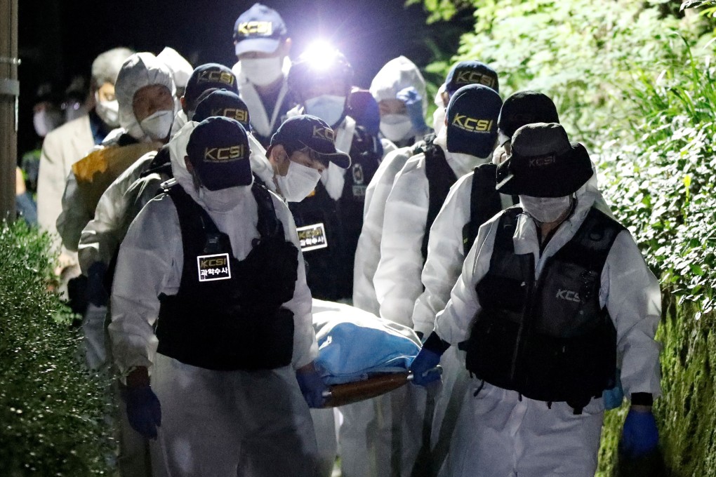 Police officers carry the body of Seoul Mayor Park Won-soon out of the woods at Mt Bugak. Photo: Reuters