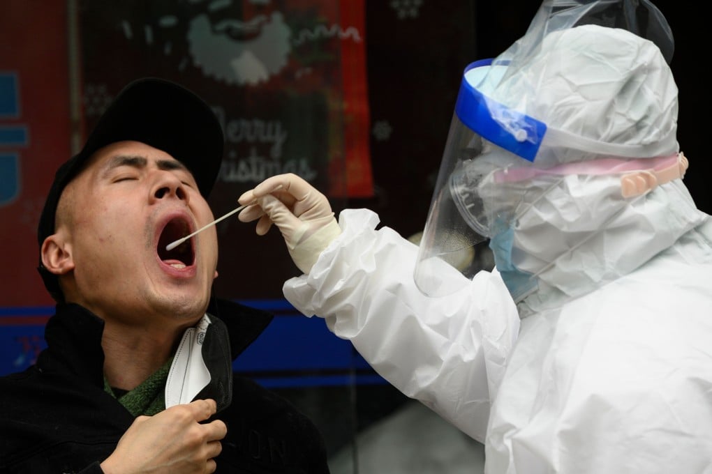 A medical worker wearing a hazmat suit gets a swab sample at a health clinic in Wuhan to check if a man has the coronavirus on March 28. Photo: AFP