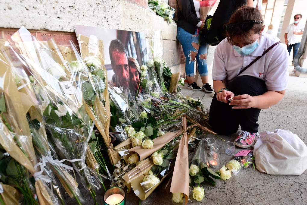 People leave flowers as thousands of people take part in a remembrance march in tribute to French bus driver Philippe Monguillot. Photo: EPA
