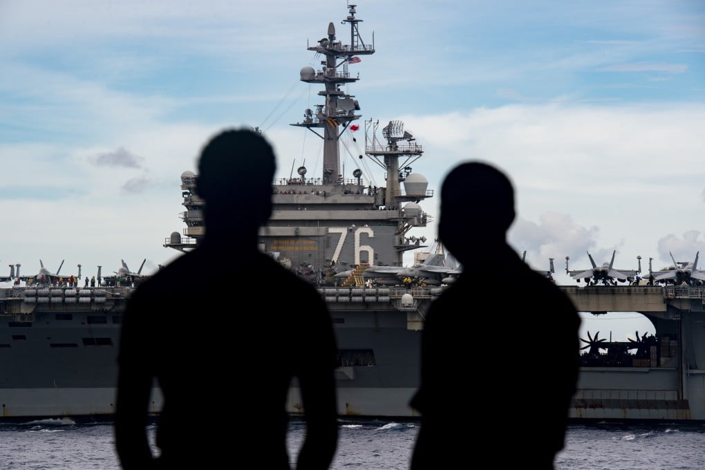 Sailors observe the aircraft carrier USS Ronald Reagan (CVN 76) from USS Nimitz (CVN 68) as the Nimitz and Ronald Reagan carrier strike groups steam in formation last week. Photo: EPA-EFE