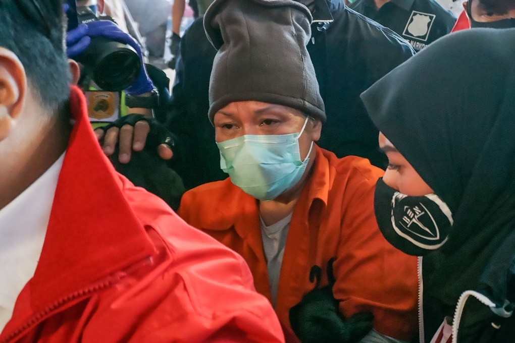 Maria Lumowa, a fugitive for the last 17 years, is escorted by officials upon her arrival in Jakarta on July 9, 2020. Photo: AFP