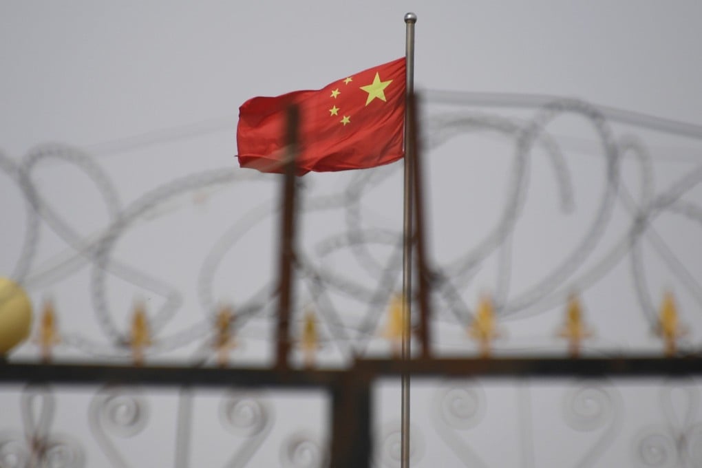 The Chinese flag flies behind razor wire at a housing compound in the western Xinjiang region. Photo: AFP