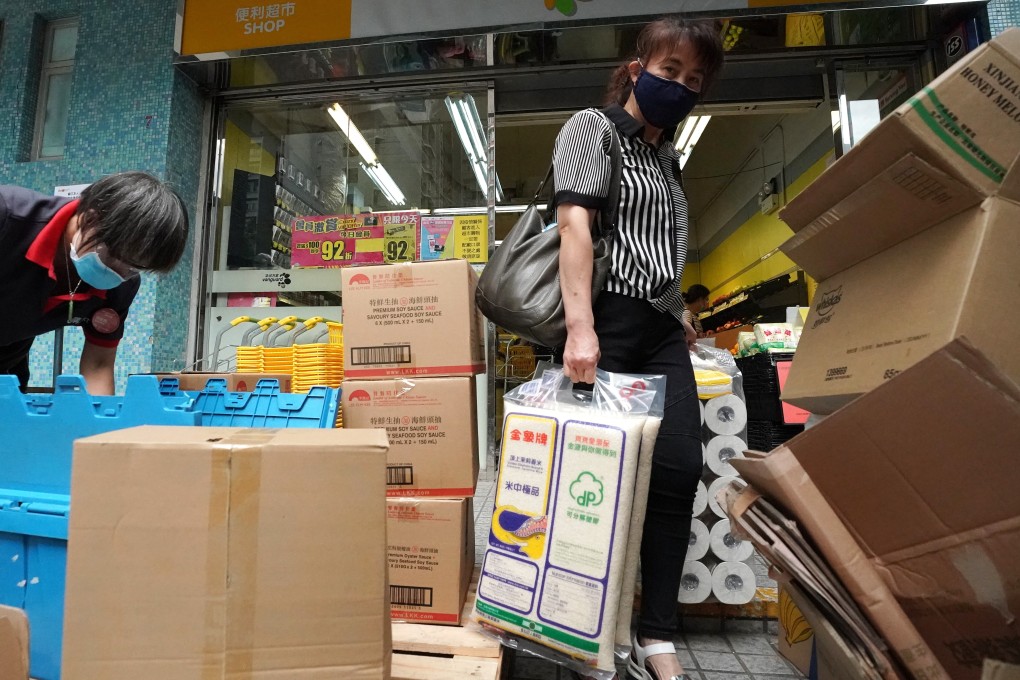 A woman walks out of a supermarket in Tsz Wan Shan on Tuesday with bags of rice and toilet rolls. Photo: Felix Wong