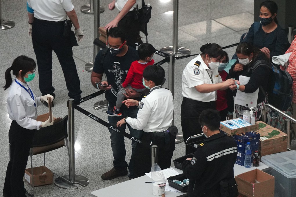 Arriving passengers undergo screening and are issued with electronic wristbands to monitor their movements during quarantine, at the Hong Kong International Airport during a coronavirus outbreak in the city, on March 20. Photo: Sam Tsang