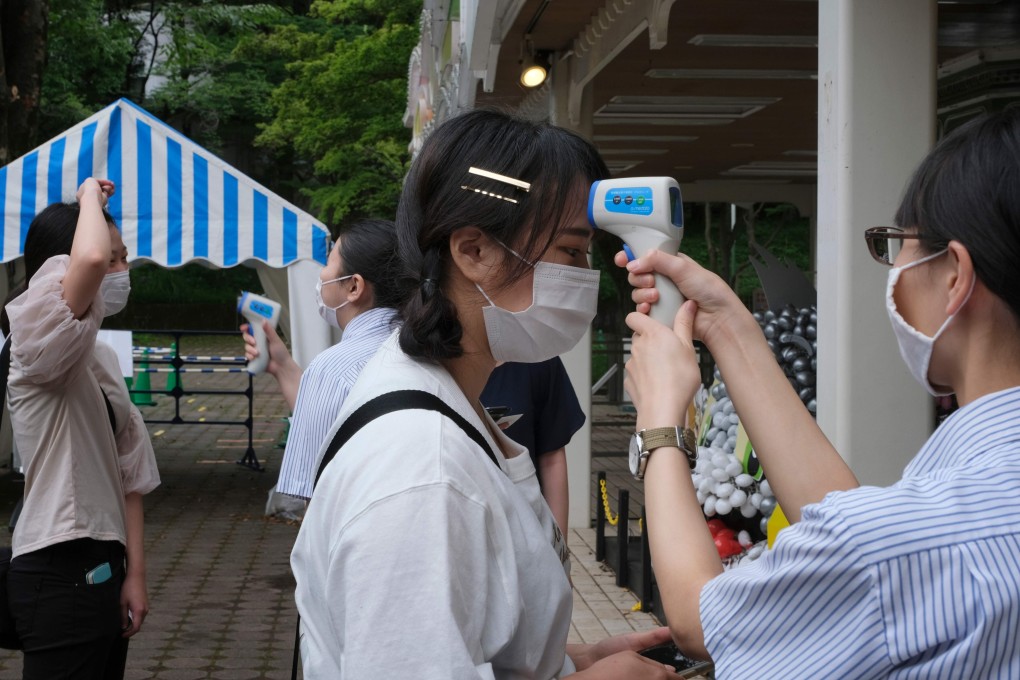 Visitors to a Tokyo amusement park have their temperatures checked. Photo: AFP