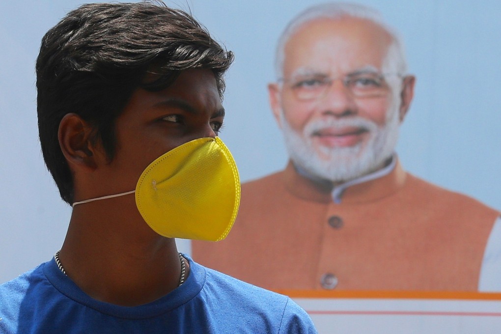 An Indian youth in front of a poster of Prime Minister Narendra Modi during a lockdown in Bangalore on May 1. Although the country's initial 21-day lockdown was extended, case numbers have continued to climb. Photo: EPA-EFE