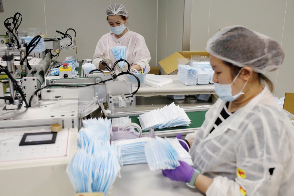 Workers collect surgical masks from a production line at a factory in Taoyuan, Taiwan, on April 6. The Taiwanese government has engaged in a campaign of ‘mask diplomacy’ in recent months in an attempt to raise its international standing. Photo: Reuters