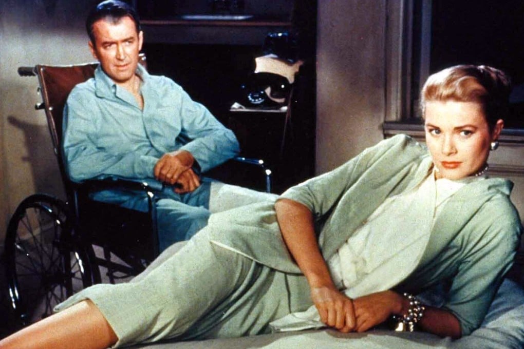 James Stewart and Grace Kelly in Alfred Hitchcock’s Rear Window – one of five films to watch at home about being stuck inside a house.