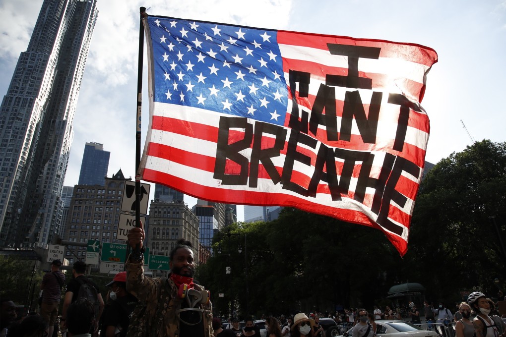 A protester holds up an American flag with the words “I Can't Breathe” as he walks in Manhattan after a George Floyd demonstration in Brooklyn, New York, on June 4. Photo: EPA-EFE