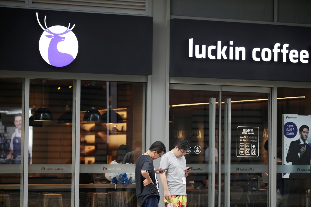 People walking past a Luckin Coffee outlet in Beijing. The coffee chain has brought in administrators and financial advisers to reorganise its debt. Photo: Reuters