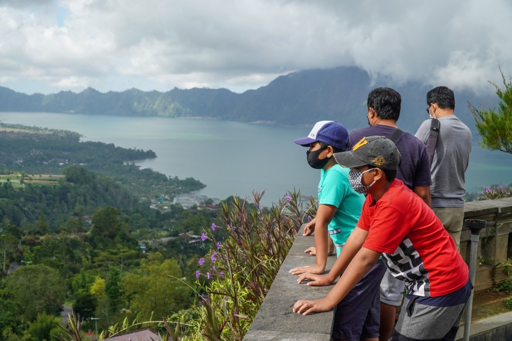 Visitors wearing face masks admire the scenery at Lake Batur in Indonesia. Indonesia’s tourism industry is looking at ways of luring visitors back to the country. Photo: SOPA Images/LightRocket via Getty Images