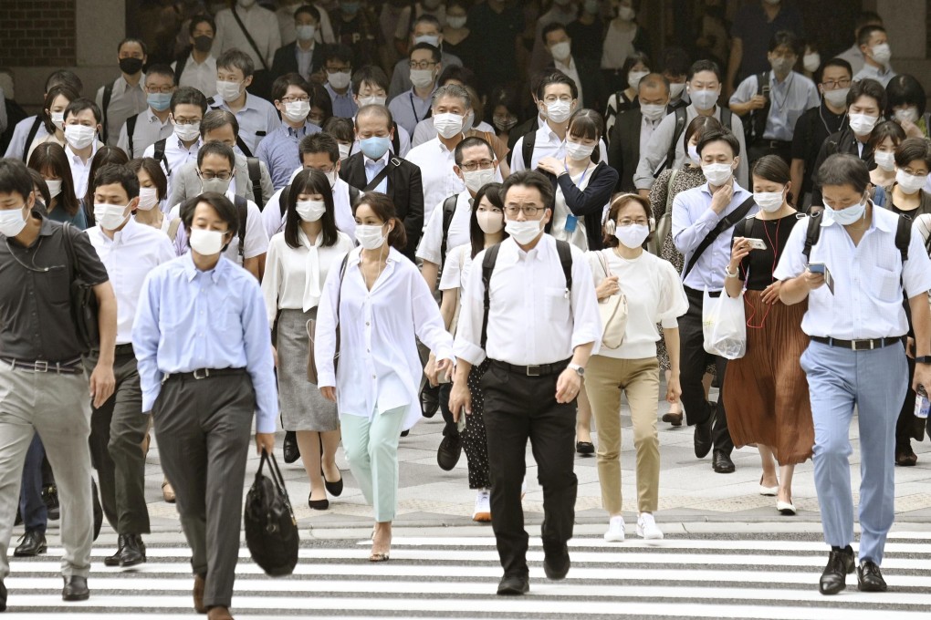 People wearing face masks head to work near JR Tokyo Station. Photo: Kyodo