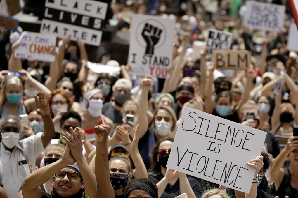 People hold signs as they listen to a speaker in downtown Kansas City on June 5, during a rally to protest the death of George Floyd. Floyd’s death in police custody in Minnesota gave rise to massive anti-racism protests in the US and made “Black Lives Matter” a global rallying cry. Photo: AP
