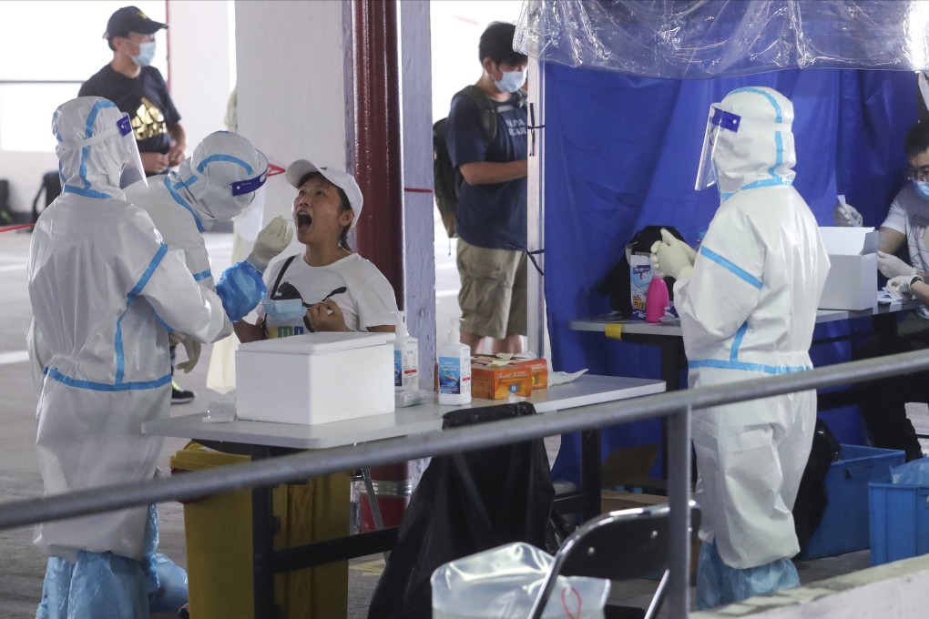 Medical workers take samples from taxi drivers at a temporary specimen collection point for Covid-19 testing. Photo: Edmond So