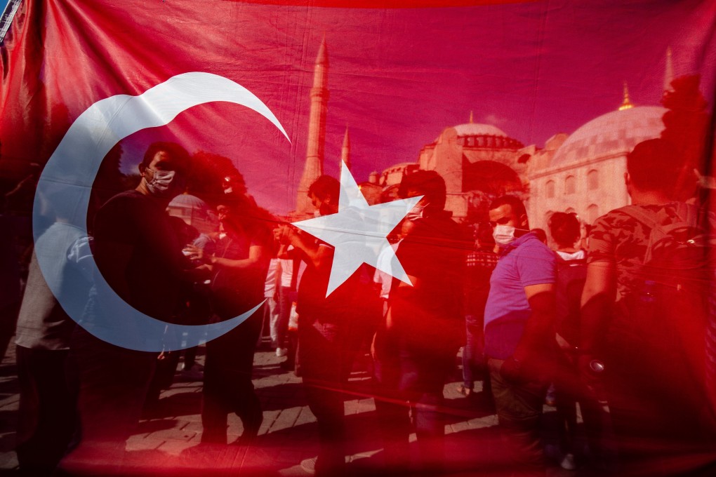 People celebrate behind a Turkish national flag in front of the Hagia Sophia after a court decision to revoke its status as a museum. Photo: DPA