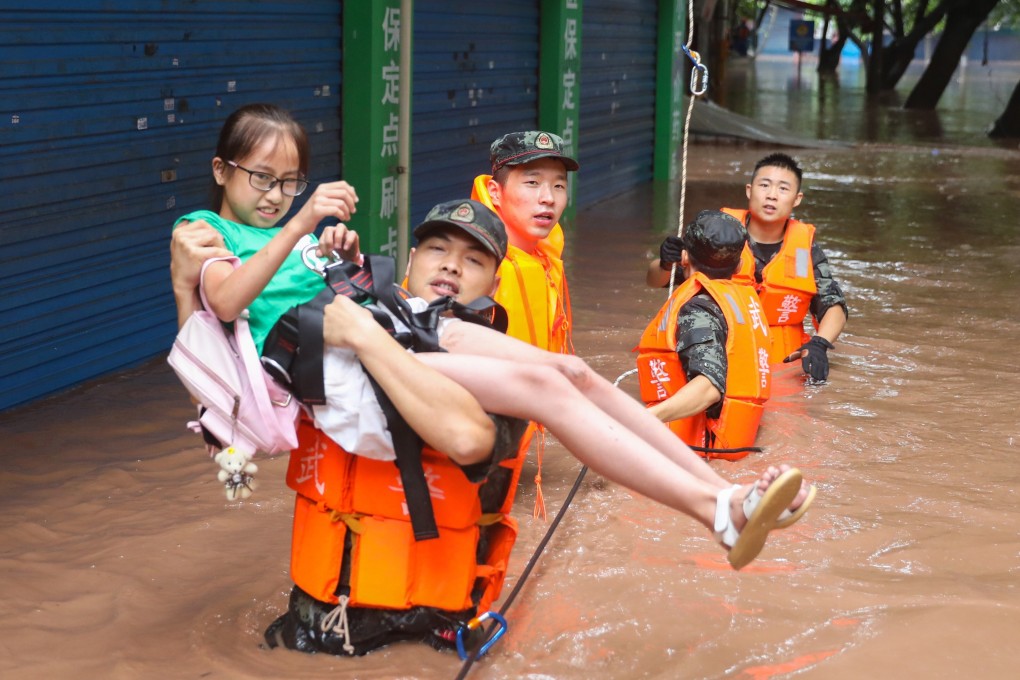 A paramilitary police officer carries a young girl to safety in Wanzhou, southwest China’s Chongqing municipality, on Thursday. Photo: EPA-EFE