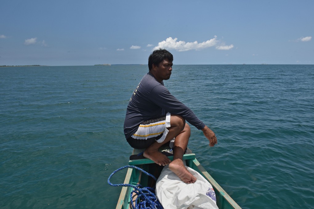 A crew member sits at the bow of a fishing vessel anchored at the mouth of the South China Sea off the town of Infanta in the Philippines’ Pangasinan province in June 2016, as they prepare for a fishing expedition to Scarborough Shoal, part of a long-running territorial row with China. Photo: AFP
