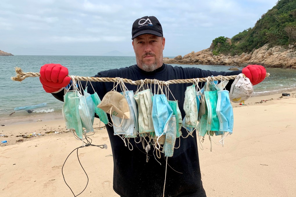 Gary Stokes, co-founder of marine conservation group OceansAsia, shows face masks that washed up on the beach of Soko Islands, following an outbreak of the coronavirus, in Hong Kong. Photo: Reuters