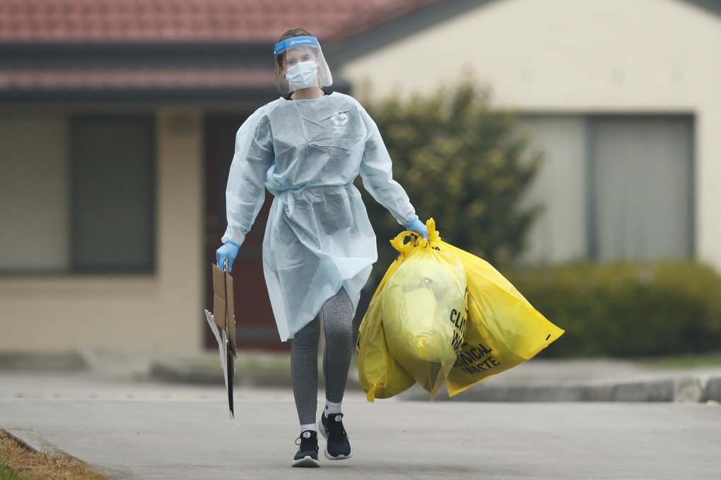 Medical staff dispose of clinical waste at the St Basil’s Home for the Aged Care in Victoria, which has had an outbreak of Covid-19. Photo: EPA