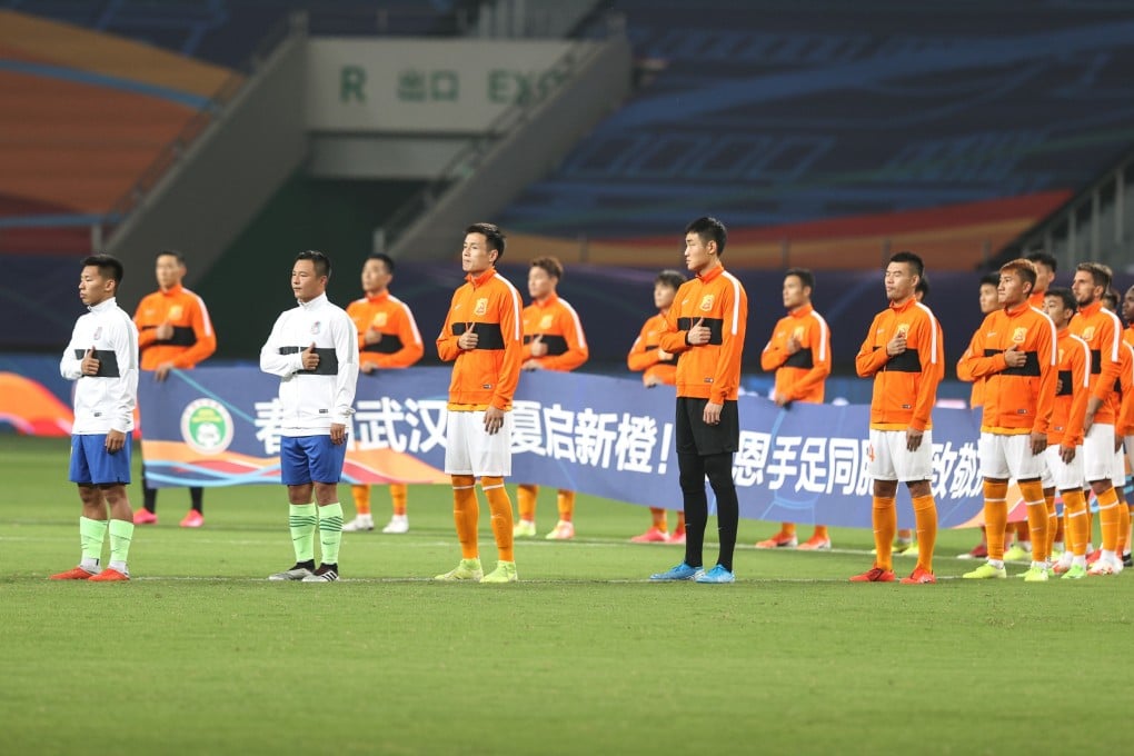 Players from both sides pay their respects for the medical workers fighting against Covid-19 ahead of the opening Chinese Super League match between Wuhan Zall and Qingdao Huanghai. Photo: Xinhua