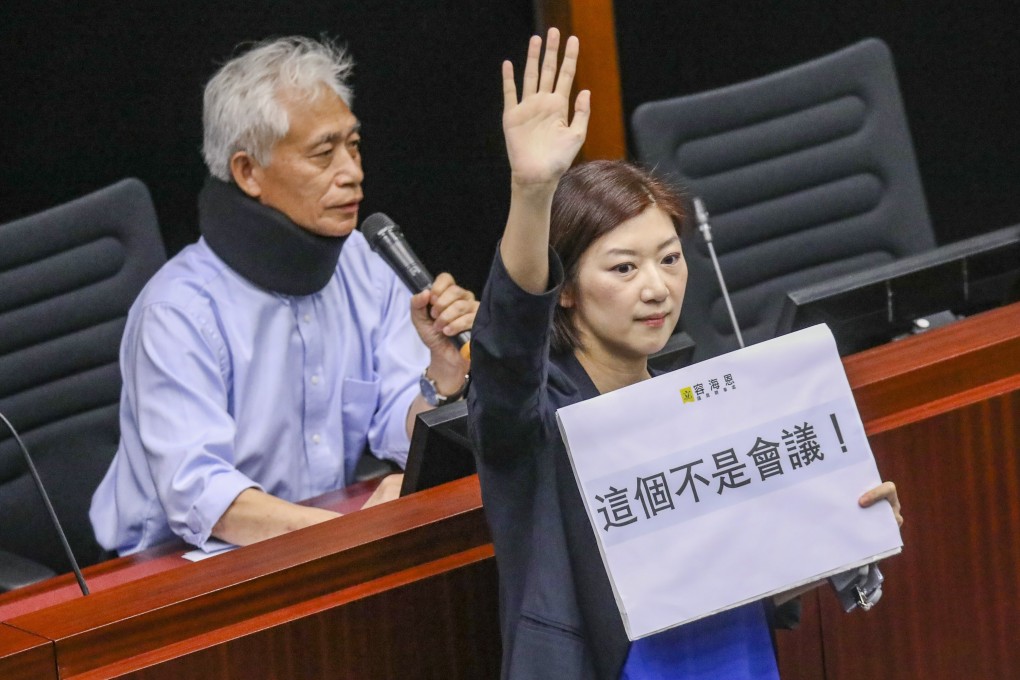 Eunice Yung Hoi-yan, right, holds up a sign while fellow lawmaker Leung Yiu-chung speaks during a meeting of the Legislative Council's Bills Committee on May 6, 2019. Yung is one of four female Legco members confirmed to be leaving, putting Hong Kong at risk of a new low in women’s political representation. Photo: Dickson Lee