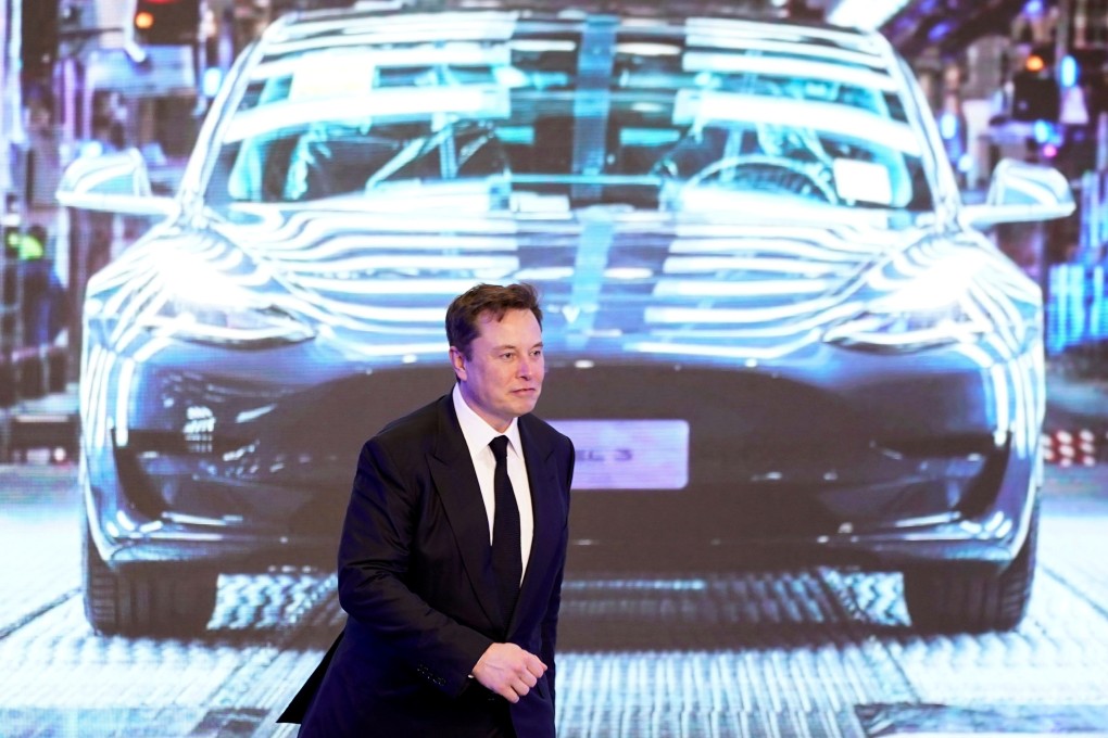 Tesla’s CEO Elon Musk walks in front of an image of Tesla’s Model 3 car in Shanghai on January 7. Photo: Reuters