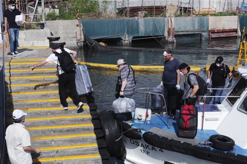 Incoming sailors disembark and change crew at the Hoi Fai Road Promenade in Tai Kok Tsui on July 26. Industry experts have urged the Hong Kong government to suspend quarantine exemption and changes for sea crew amid an uptick in imported Covid-19 cases involving seafarers. Photo: Edmond So