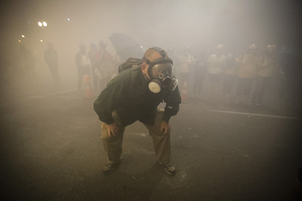 A demonstrator wears a gas mask as federal officers deploy tear gas in Portland. Photo: AP