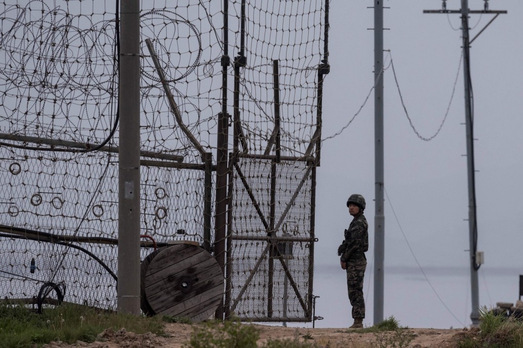 A soldier stands at a fence at the demilitarised zone separating North and South Korea, where a 24-year-old defector is believed to have swum back to the North. Photo: AFP