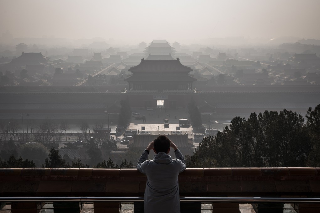 A man standing at a viewing area of Jingshan Park takes photos of the Forbidden City as a thick haze engulfs Beijing, China, 09 December 2019. Photo: EPA-EFE