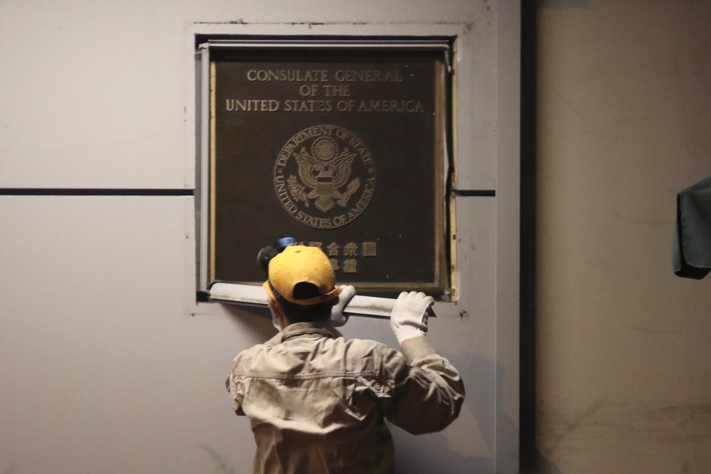 A worker removes a plaque from the wall of the US consulate in Chengdu on Sunday. Photo: Simon Song
