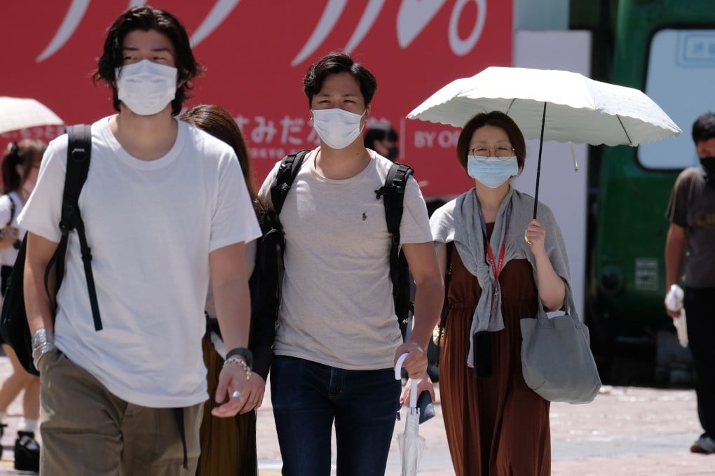 People wearing face masks walk across Tokyo’s Shibuya Crossing. Photo: AFP