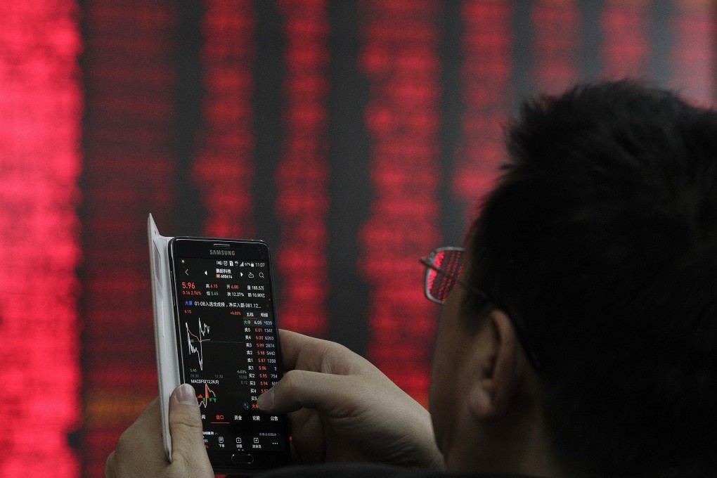 A man checks stock prices through his smartphone at a brokerage house in Beijing on Wednesday, Jan. 9, 2019. Contrary to global conventions, China denotes gains and advances in red and represents losses and declines in green. Photo: AP Photo