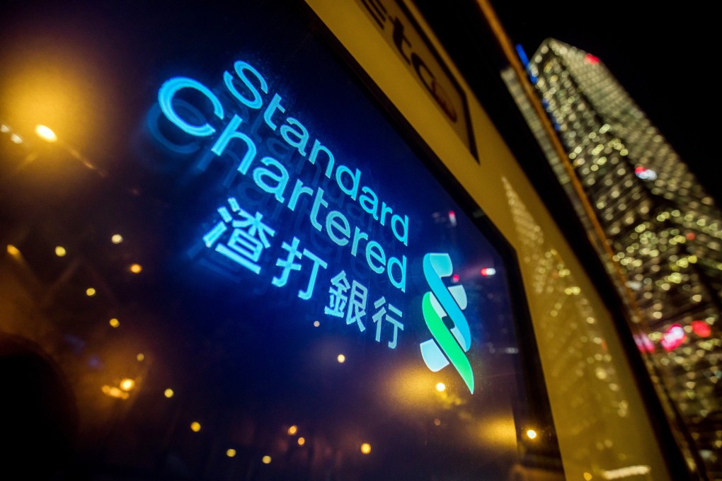 Signage is illuminated at a Standard Chartered branch in Hong Kong. Photo: Bloomberg