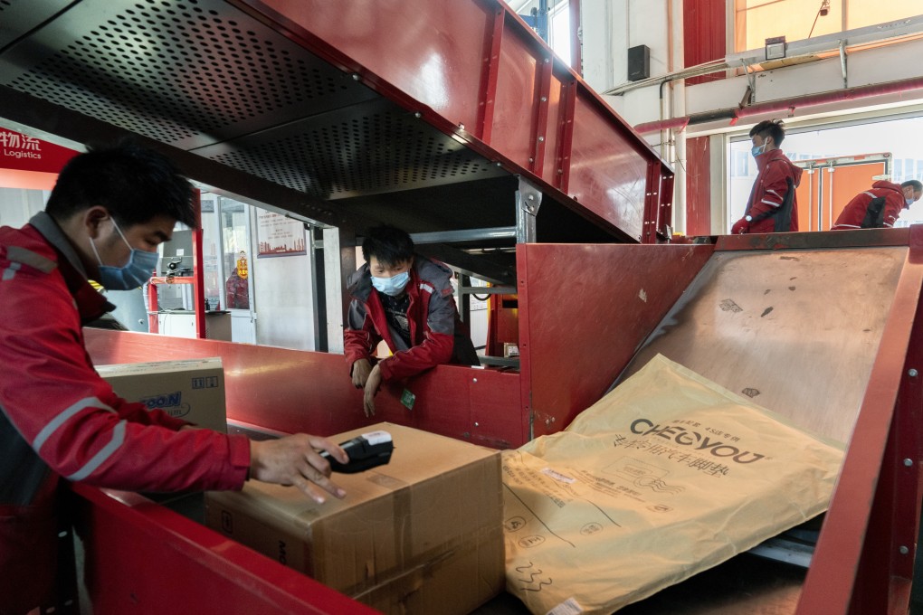 Employees wearing protective masks sort parcels at a JD.com Inc. delivery station in Beijing on Tuesday, April 14, 2020. Photo: Bloomberg