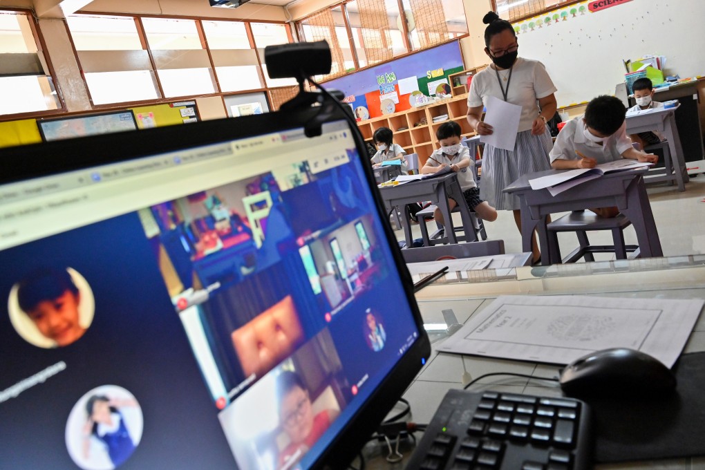 A teacher at an international school in Bangkok attends to students both in the classroom and online after reopening in June amid the coronavirus pandemic. Photo: AFP