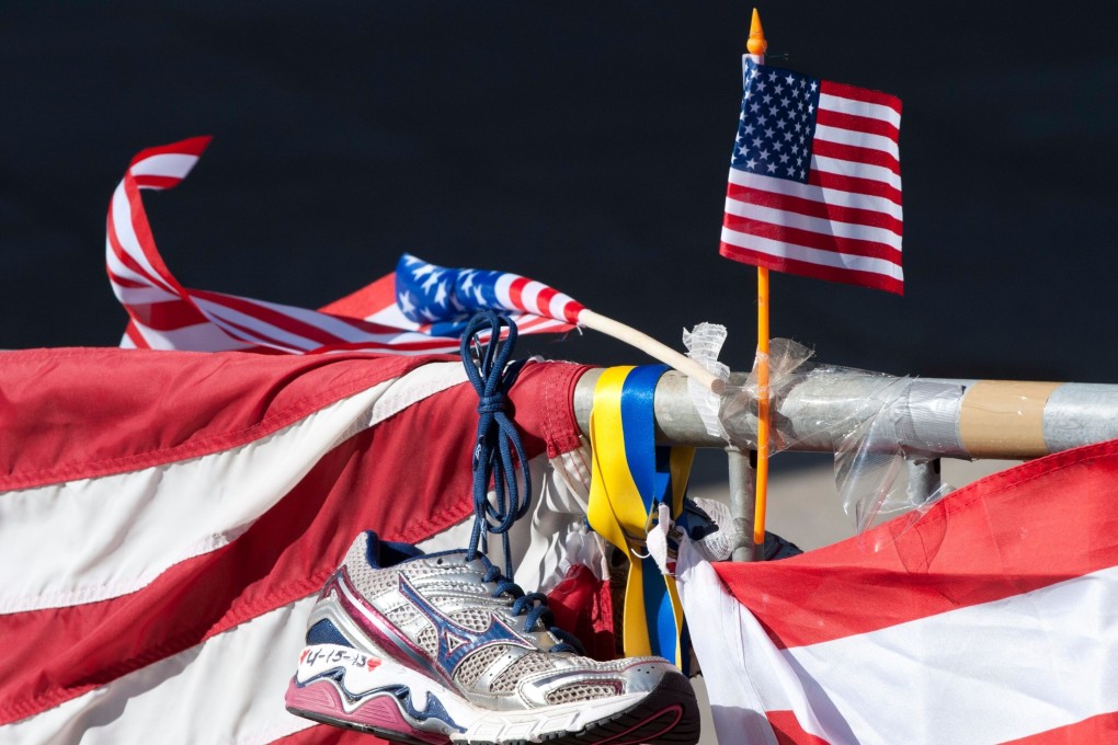 A running shoe and US flag are part of a memorial on the Boston Marathon route in Boston. Photo: AFP