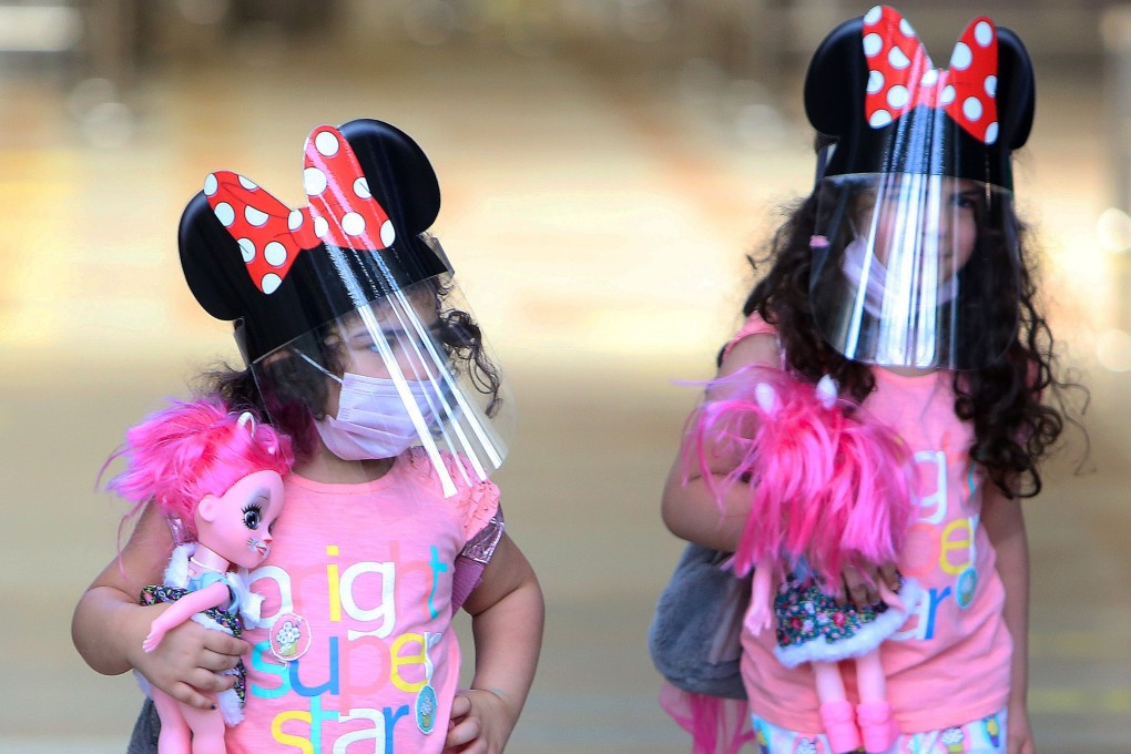 Children travelling from Kuwait international Airport, wear face masks and shields as protections against the novel coronavirus. Photo: AFP